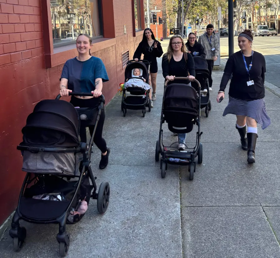 Young Parents Connect on a stroll young parents walking with strollers on the street