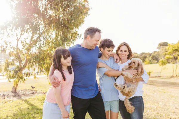 184_CoGG_Image_Library_Young teenagers playing reading_basketball_skatepark_family with dog.jpg Happy family in a park with their pet dog.