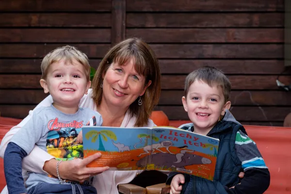 COGG-FamilyServices-3147.jpg Educator reading to children in home.