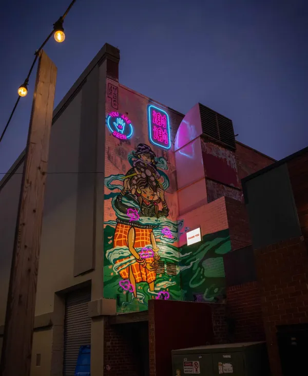 Migrant Mother Sister Illuminated mural of the multigenerational migrant experience