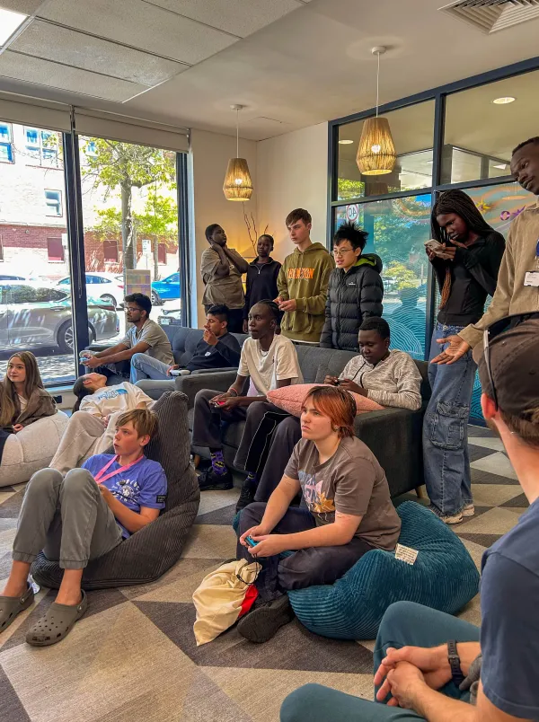 The Nest Young people sitting and standing, listening to a speaker