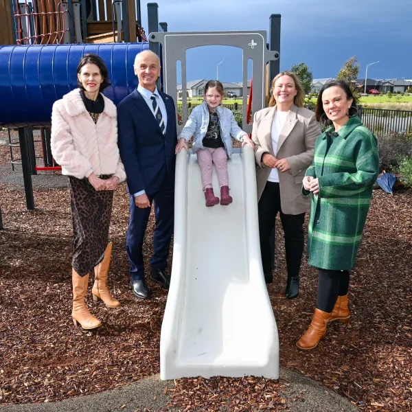City CEO Ali Wastie, Mayor Kontelj OAM, 5yo Frankie Goudge, Lara MP Ella George and Minister for Children Lizzie Blandthorn at Lara West. Adults standing around a child on a slide.
