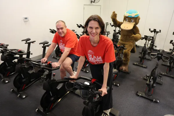 Craig Williams, Ali Wastie and Webstar Swim School mascot are getting ready for Run4Geelong Craig Williams, Ali Wastie and Webstar Swim School mascot riding exercise bikes