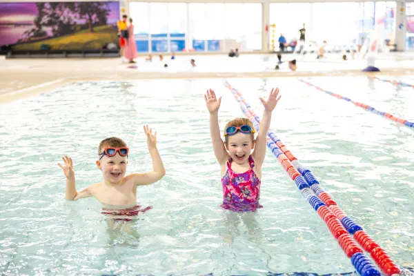 Webstar’s Swim School Two children in the pool, with their arms in the air